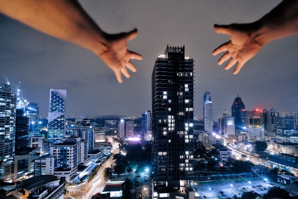 Hands reaching towards building