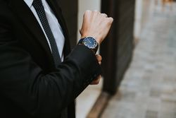Young stylish man in costume with watch