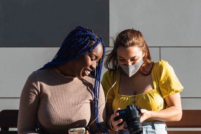 Cheerful multiethnic women looking through photos together