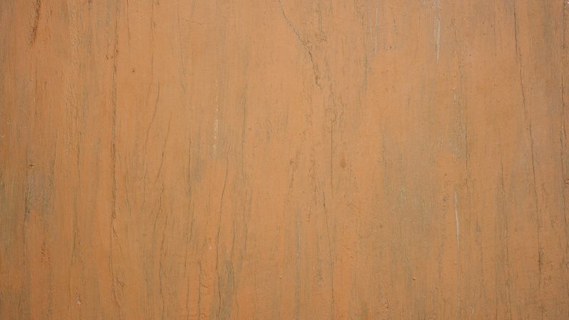 Light orange wood surface with natural vertical grain and soft rustic texture