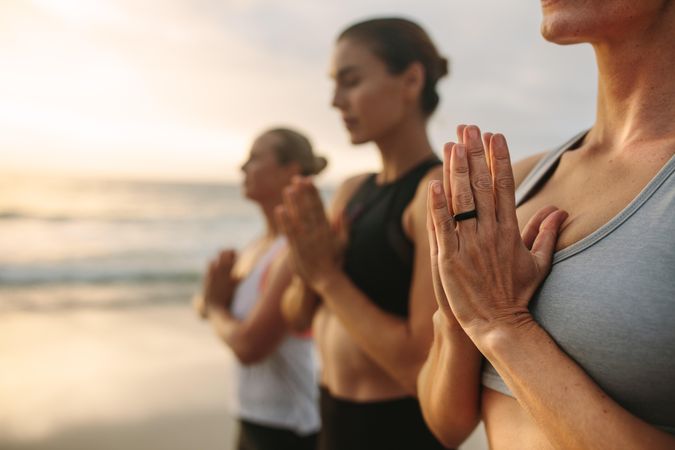 Women practicing yoga on the beach early in the morning