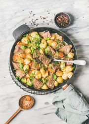 Braised beef stew with potatoes, carrots and parsley, with wooden spoon