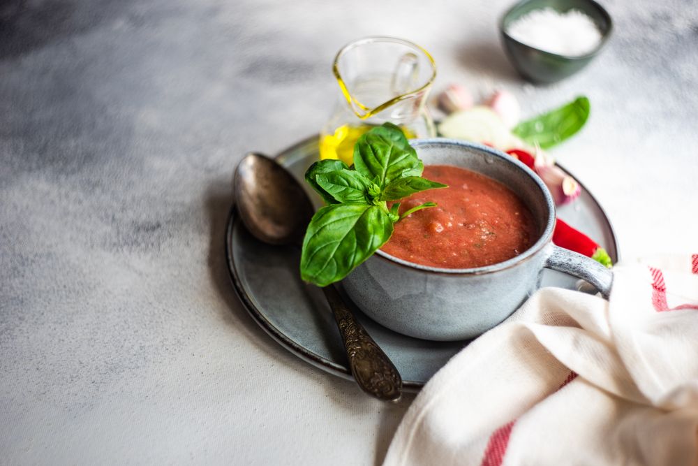 Cup of gazpacho soup with basil, garlic, pepper and olive oil with copy space