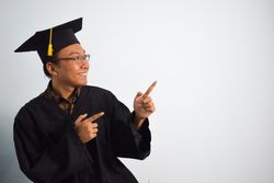 Excited male graduate in studio shoot