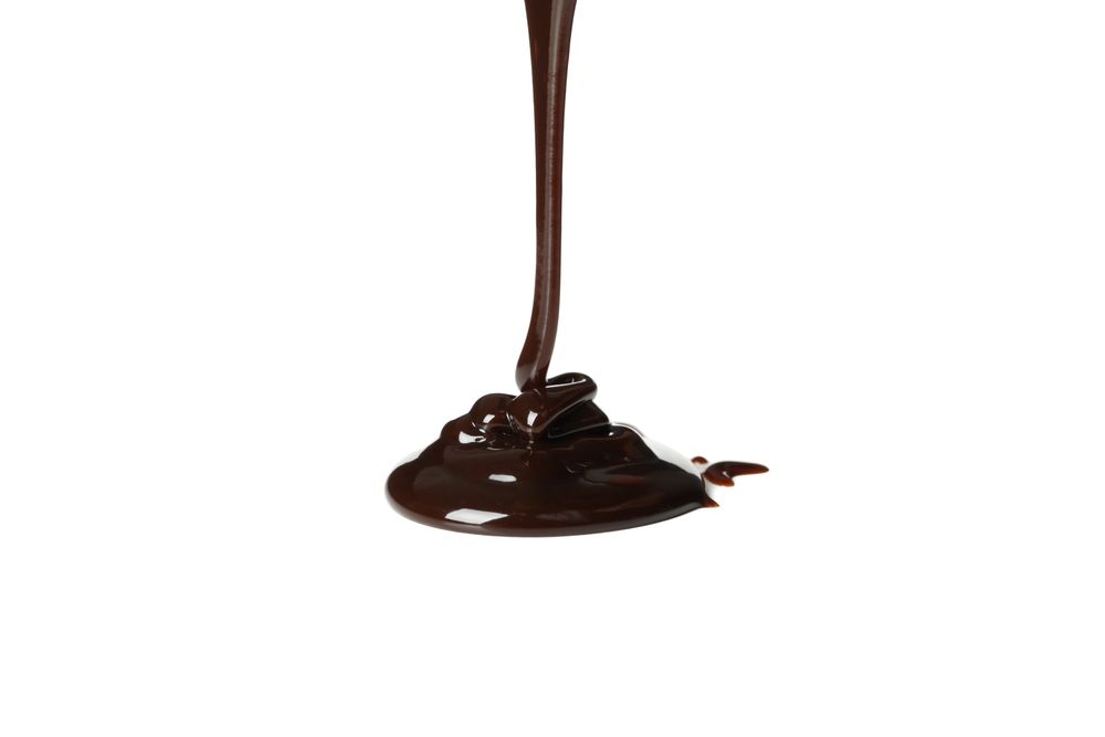 Melted chocolate is pouring, isolated on blank background