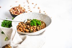 Traditional Georgian bean dish - lobio, served in modern textured ceramic bowl with napkin