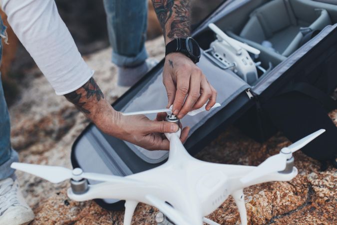 Close up of man opening bag with drone equipment on a seaside cliff