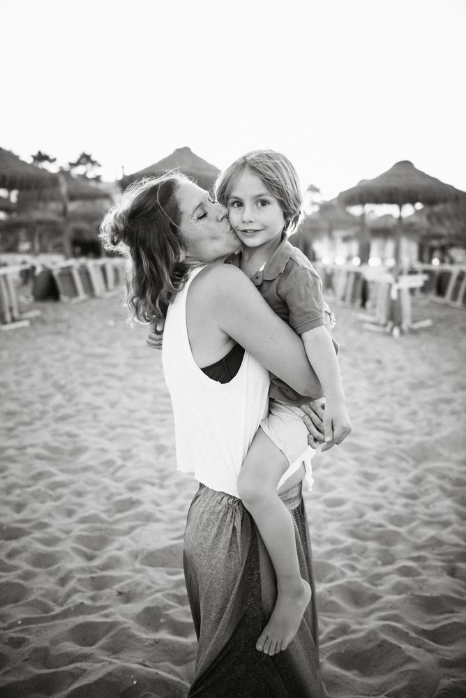 Mother kissing son on beach