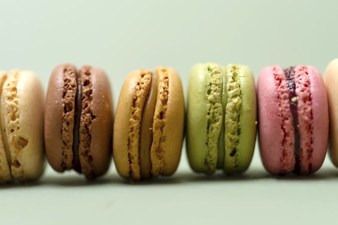 Side view of French pastel macaroons scattered on a green table