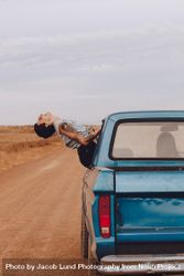 Woman sitting on car window and enjoying the ride 5qJBE4