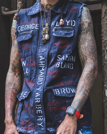 Tattooed man in blue denim vest