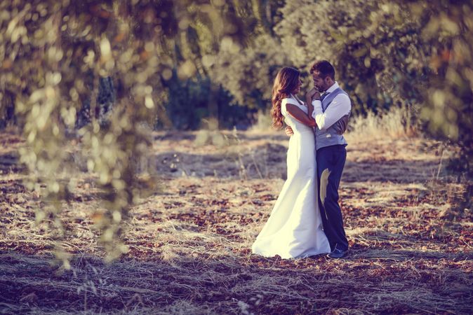 Newlyweds holding each other in nature