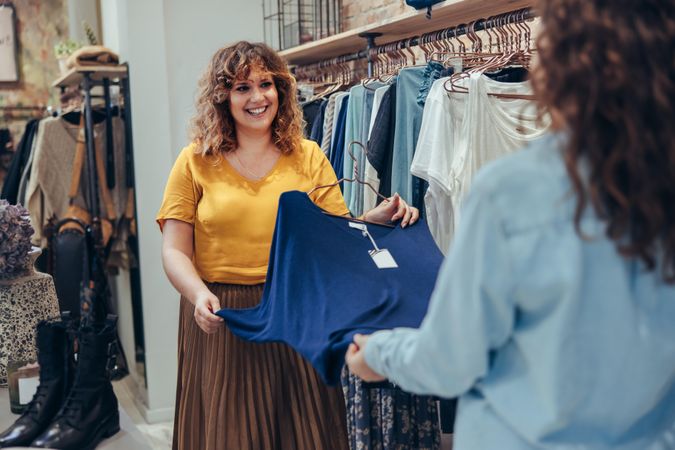 Saleswoman assisting client in clothing store