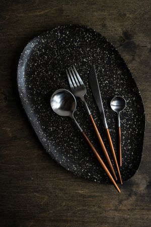 Ceramic plates and cutlery on wooden table with copy space