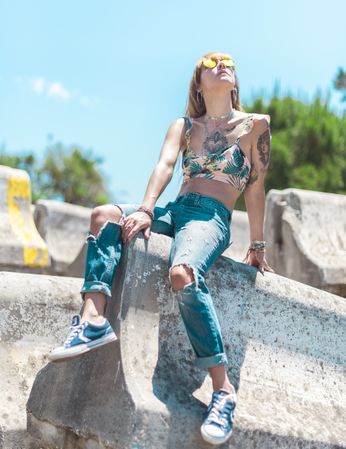 Tattooed young woman sitting outdoors