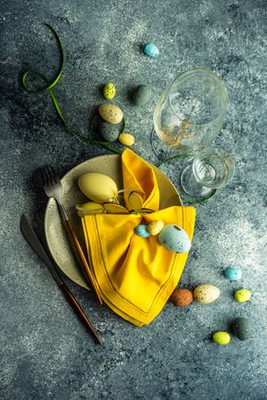 Easter table setting with pastel eggs and yellow napkin with space for text
