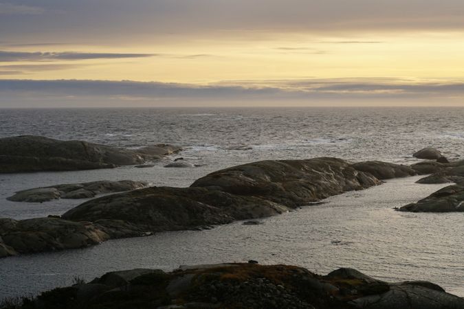 Rocky seashore and dark wavy sea in dusk