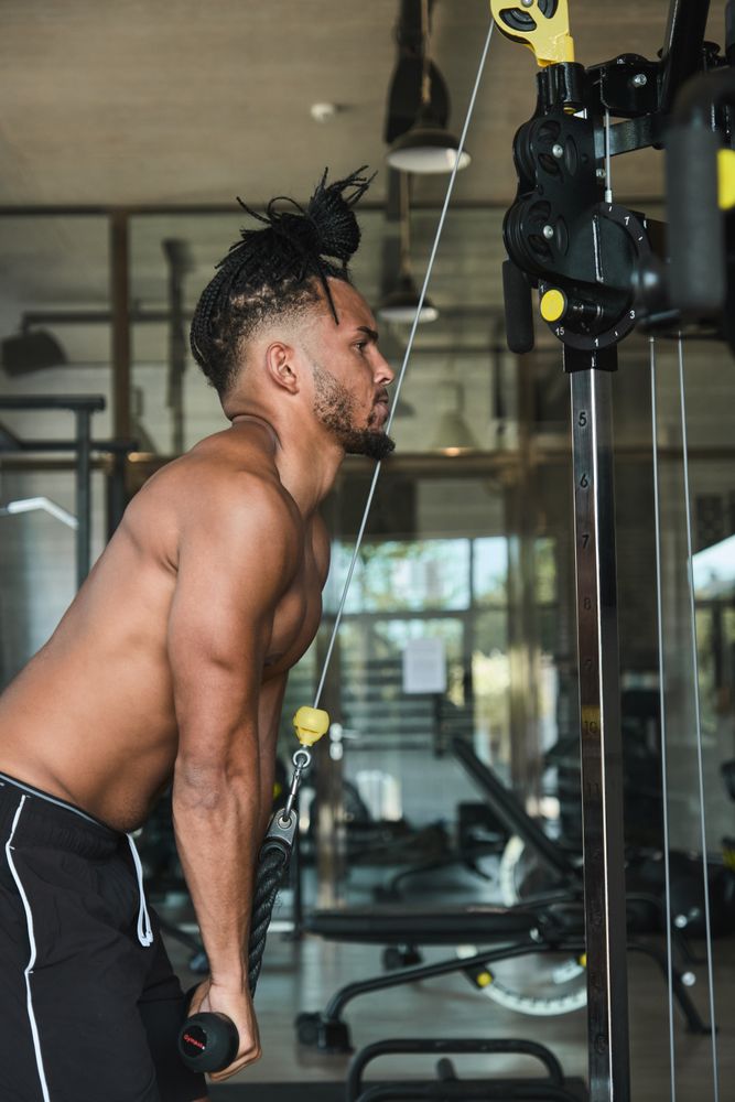Black guy using exercise machine in gym