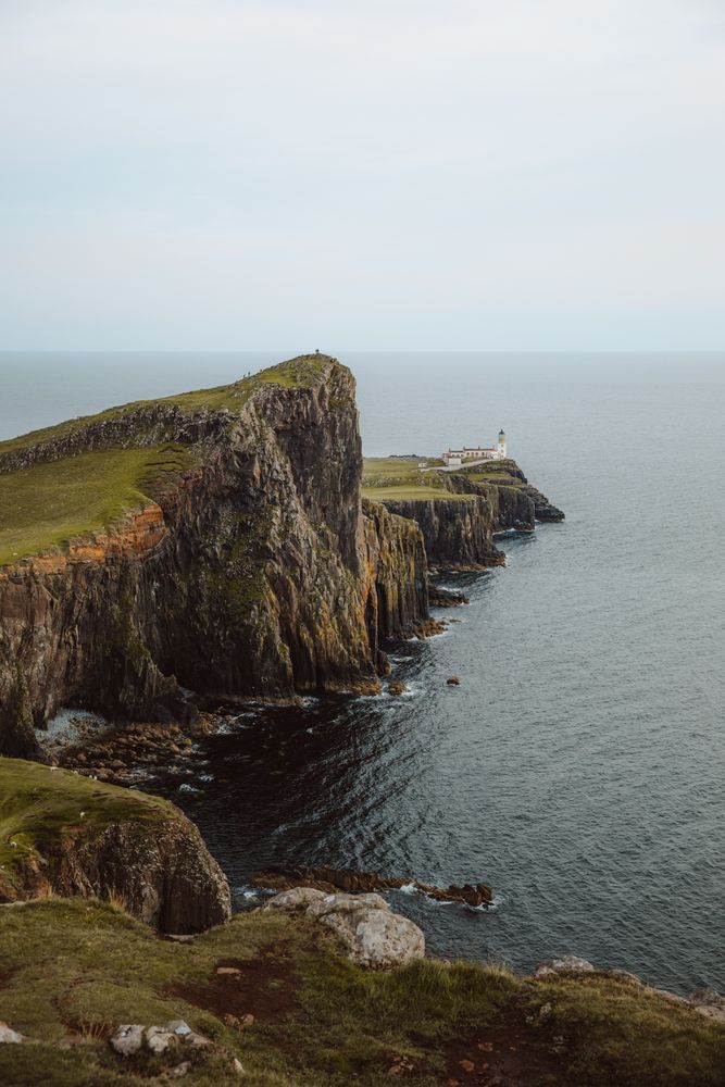 Picturesque view of lighthouse on cliff by sea