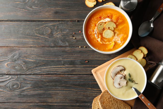 Two bowls of soup on wooden table with copy space