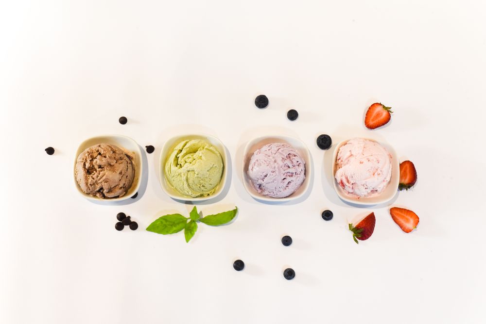 Top view of four small bowls of different flavored ice cream