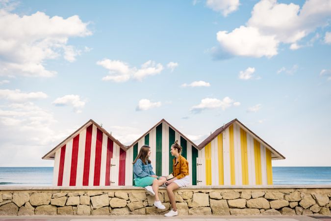 Two women sitting in front of colored kiosks