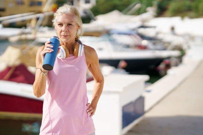 Older sportswoman drinking between exercise