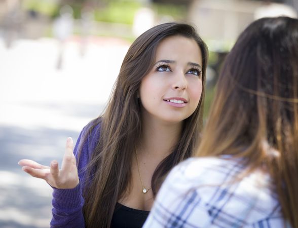 Expressive Young Woman Sitting and Talking with Girlfriend