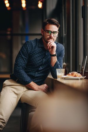 Freelance businessman at a restaurant with food and laptop in front