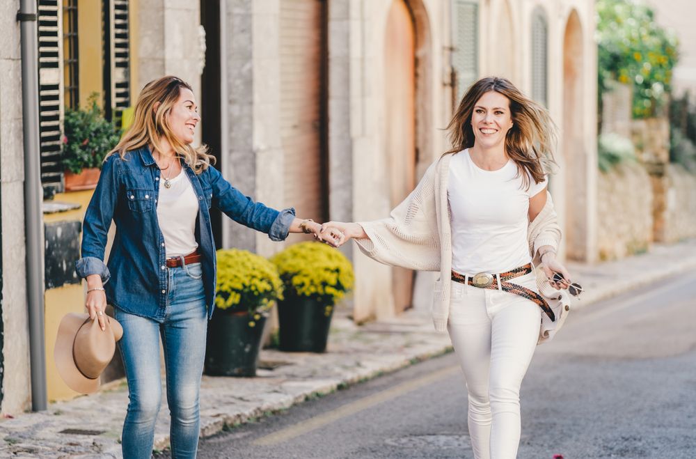Friends having fun holding hands in street