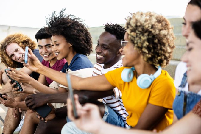 Young group of multiracial people using smartphone outdoors