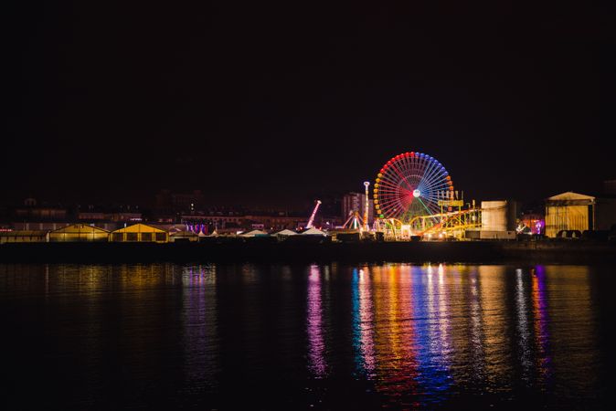 Ferris wheel on city embankment in night time