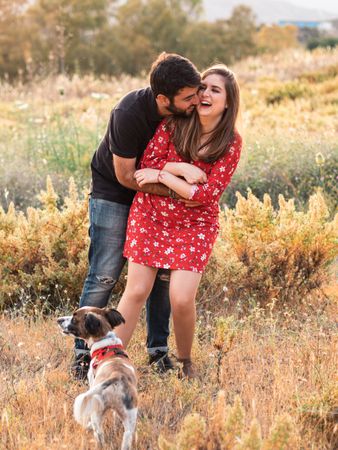 Happy couple with friendly cute dog outdoors
