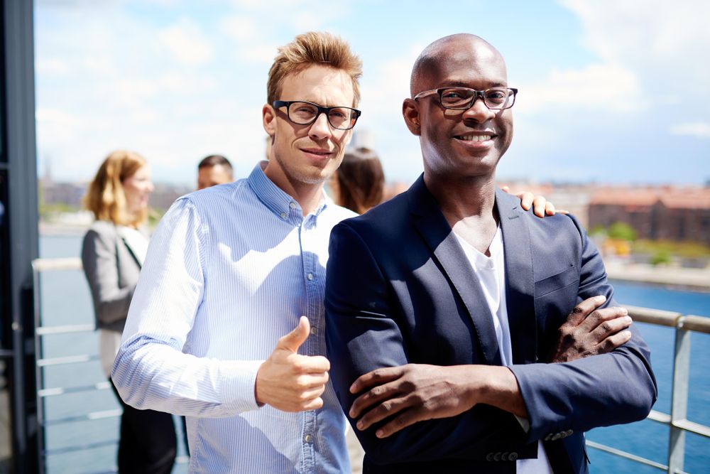 Two self-satisfied businessman standing outside