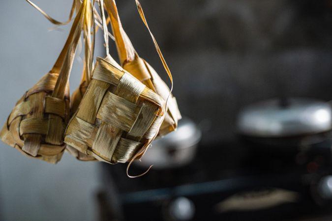 Cooked ketupat hanging on a wooden rack to keep fresh and dry
