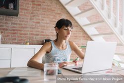 Woman working at laptop in modern loft 0PDRl0