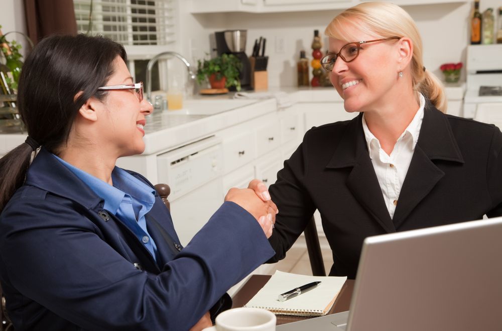 Businesswomen Shaking Hands Working on the Laptop