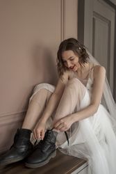 Adult confident bride in white dress and military shoes