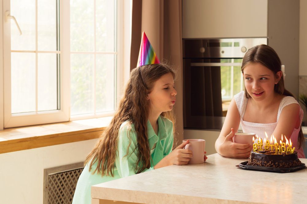 Girls birthday celebration, one blowing out candles on cake.