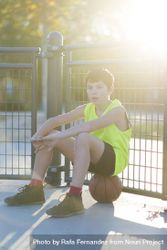 Young basketball player sitting on the court 48VPK0