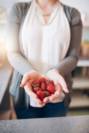 Cropped shot of a woman's hands holding strawberries
