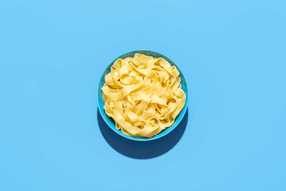 Pappardelle pasta bowl isolated on a blue background