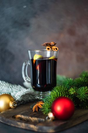 Glass of warming mulled wine surrounded by Christmas decor