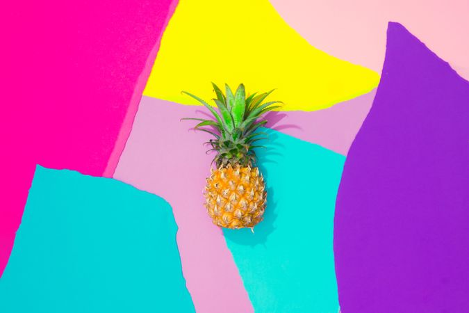 Pineapple on pattern of ripped paper in vivid colors