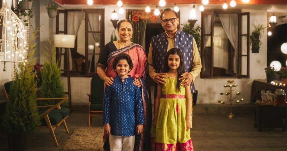 Portrait of Indian Family in Traditional Clothes Posing Together in Authentic Mumbai House.