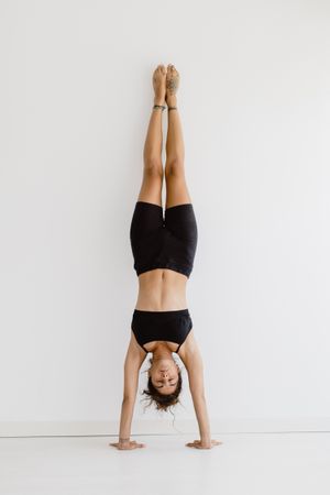 Sportive woman performing yoga pose in room