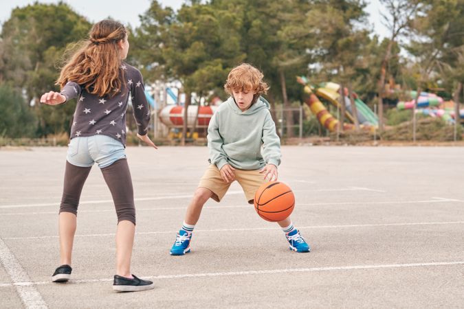 Teenagers playing basketball together in city