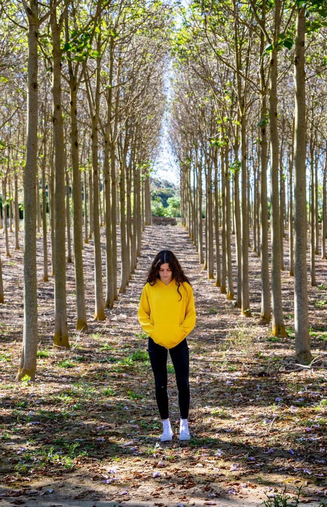 Fit teenage girl standing in forest dressed in yellow