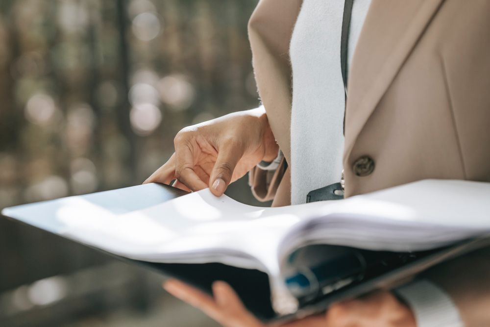 Person in blazer holding a paper document