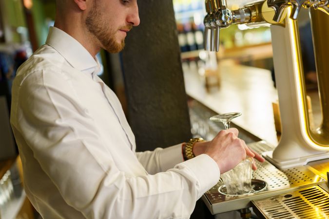 Bartender cleaning glassware behind bar